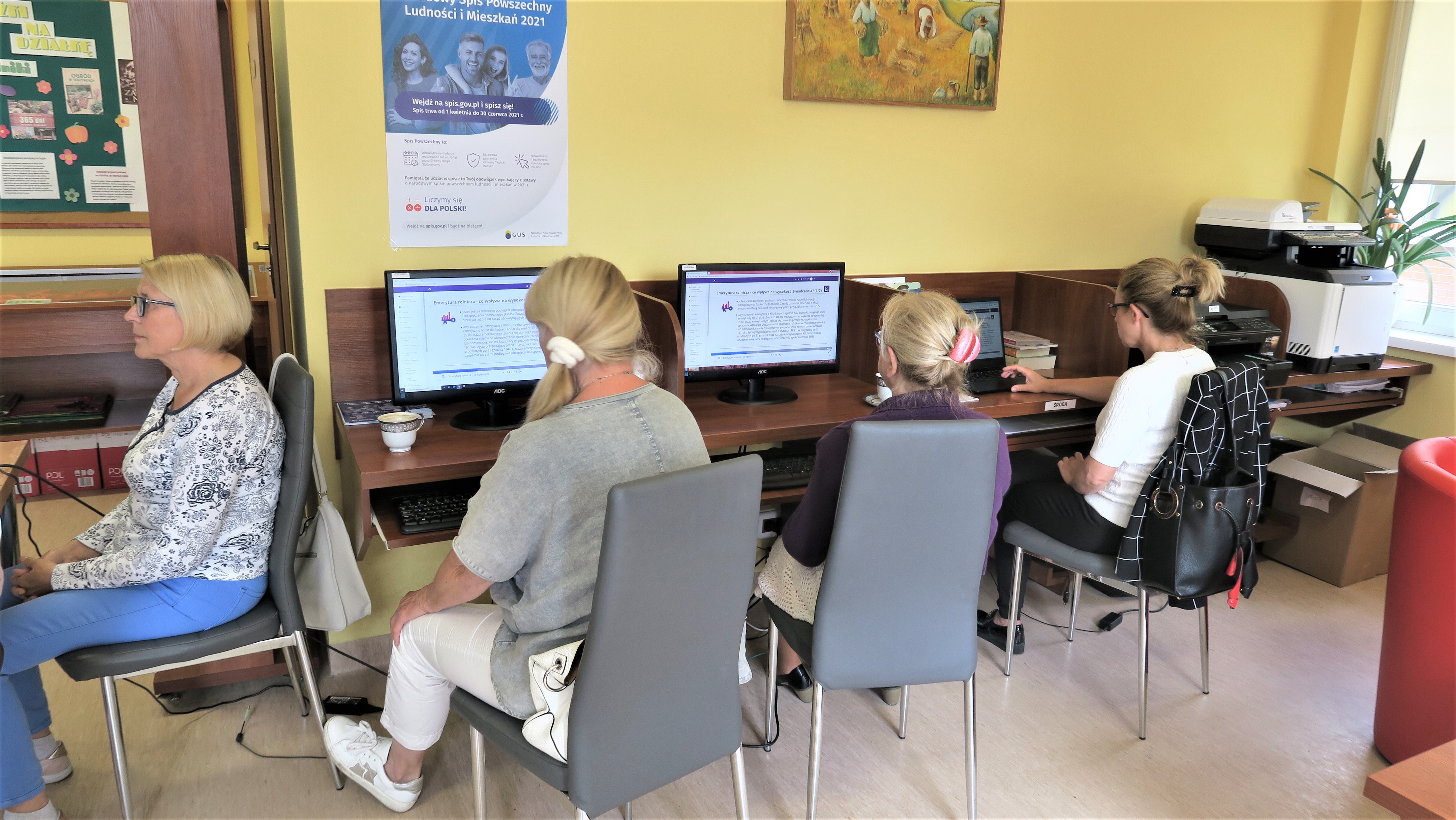 Pięć uczestniczek warsztatów siedzi przy komputerach i rozwiązuje testy o finansach